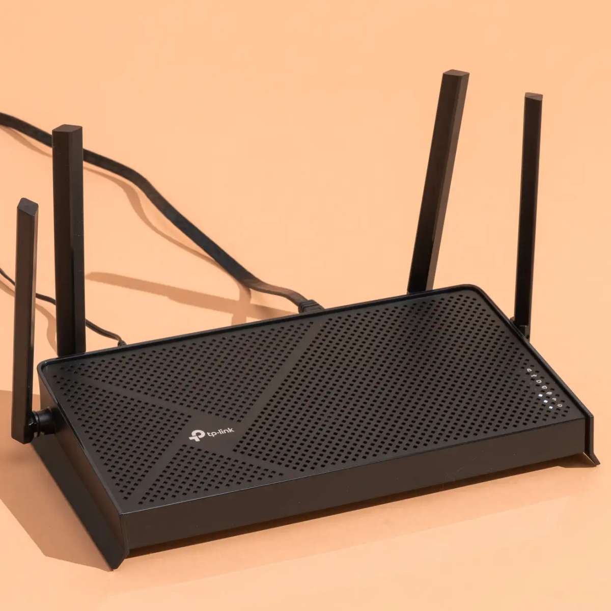 A compact black internet router with glowing LED lights on the front.